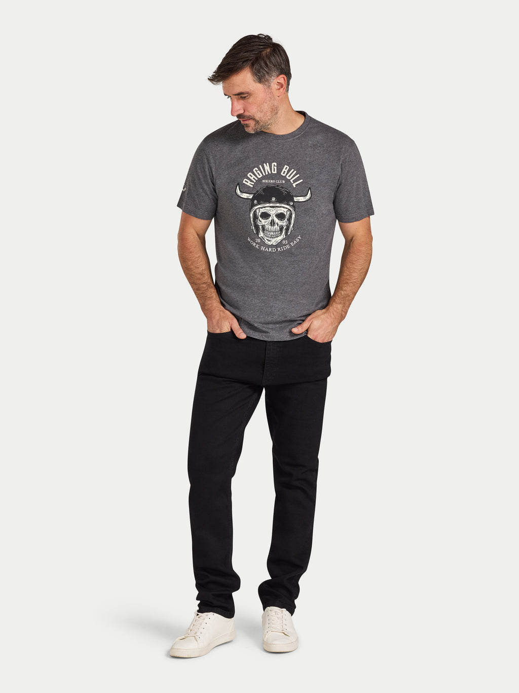 Man wearing a gray t-shirt with a graphic design and black pants on a white background